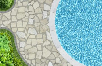 Vue aérienne d'un bord de piscine avec dallage en pierre naturelle et margelle