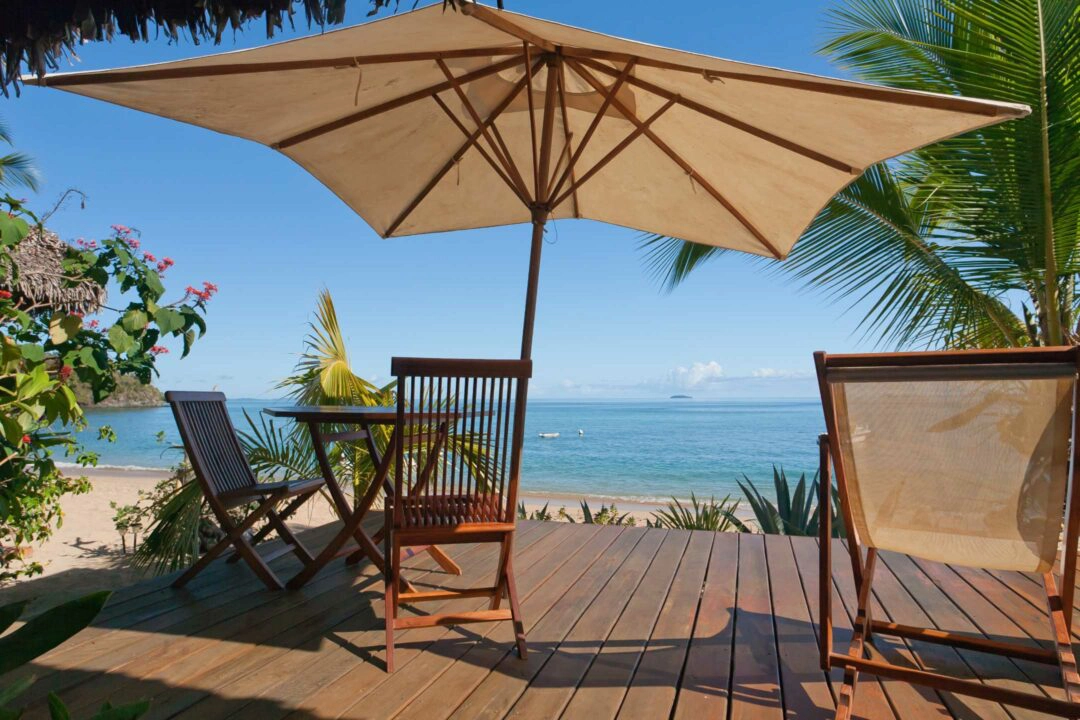 Terrasse avec transat et parasol en bord de mer