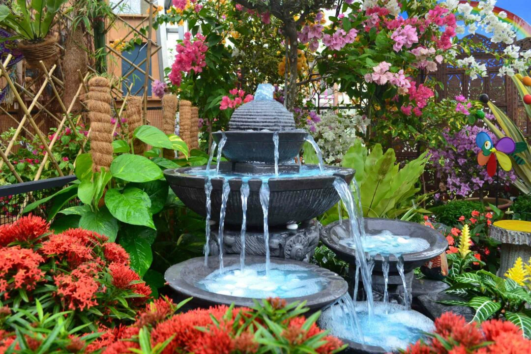 Fontaine à cascade dans un jardin fleuri
