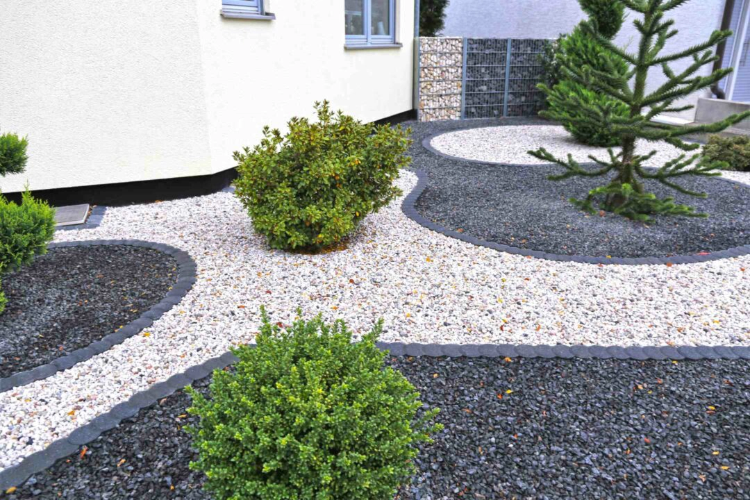 Jardin paysager aménagé avec de la pierre et des graviers blancs et noirs