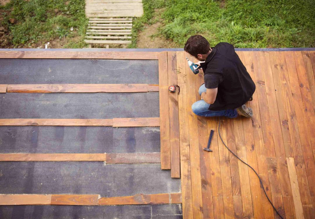 Un artisan réalise une terrasse en bois