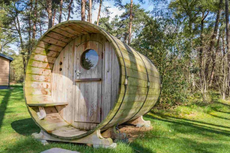 Un sauna en forme de tonneau installé dans un jardin