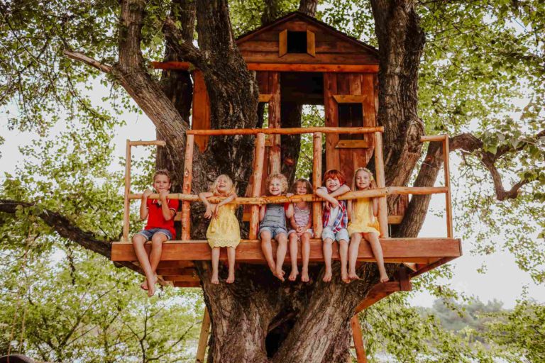 Un groupe d'enfants dans une cabane en bois construite dans un arbre