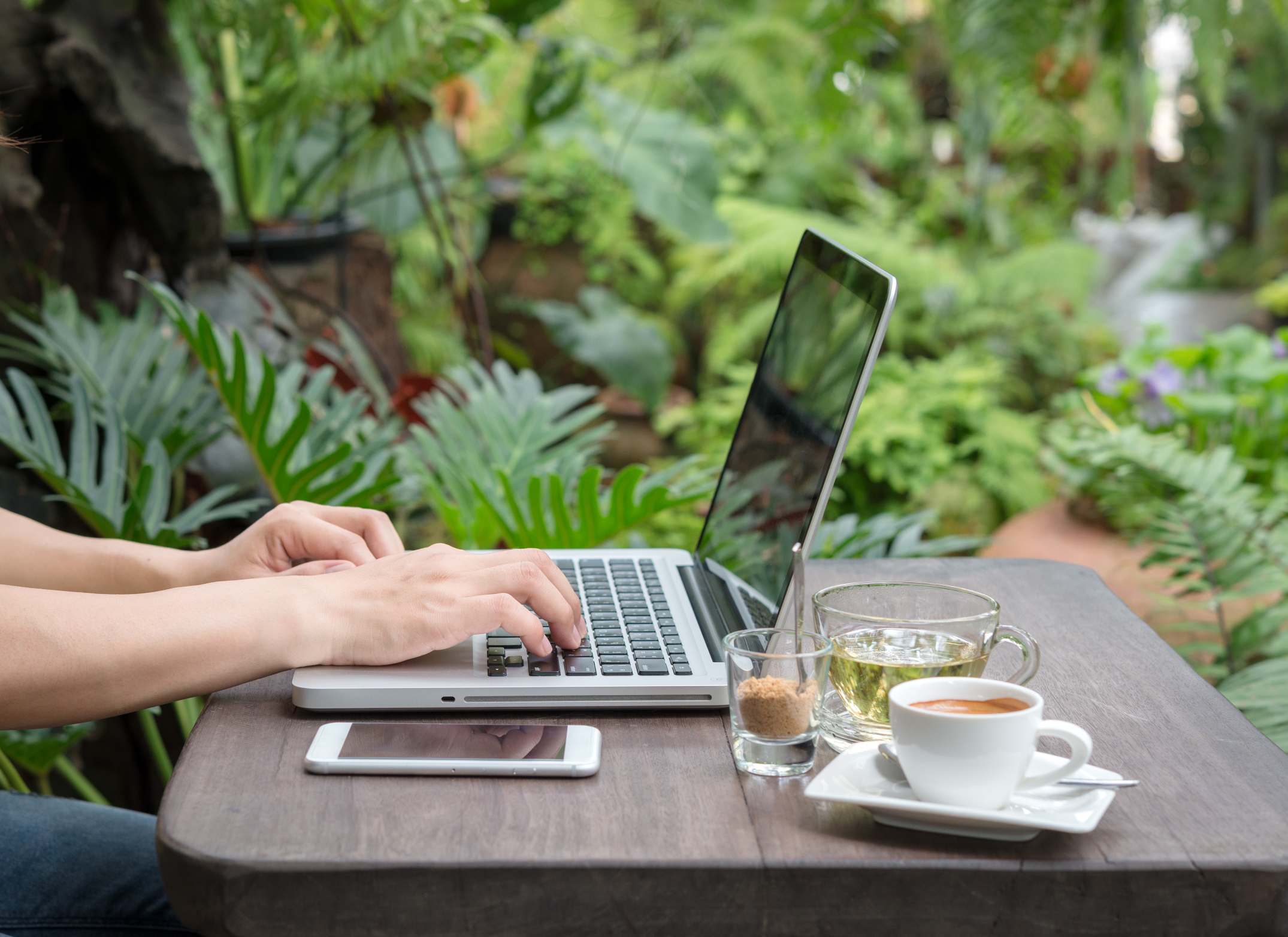 Personne qui pratique le télétravail dans son jardin