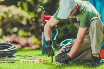 Un artisan installe un arrosage automatique dans un jardin