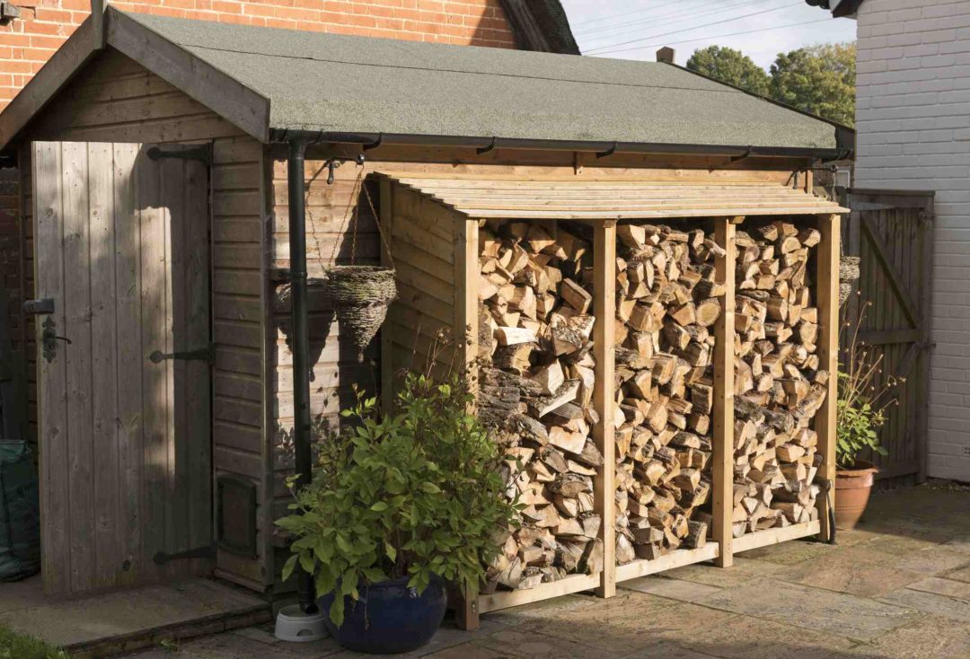 Un appentis de jardin addossé à un abri pour protéger le bois de chauffage ou de cheminée