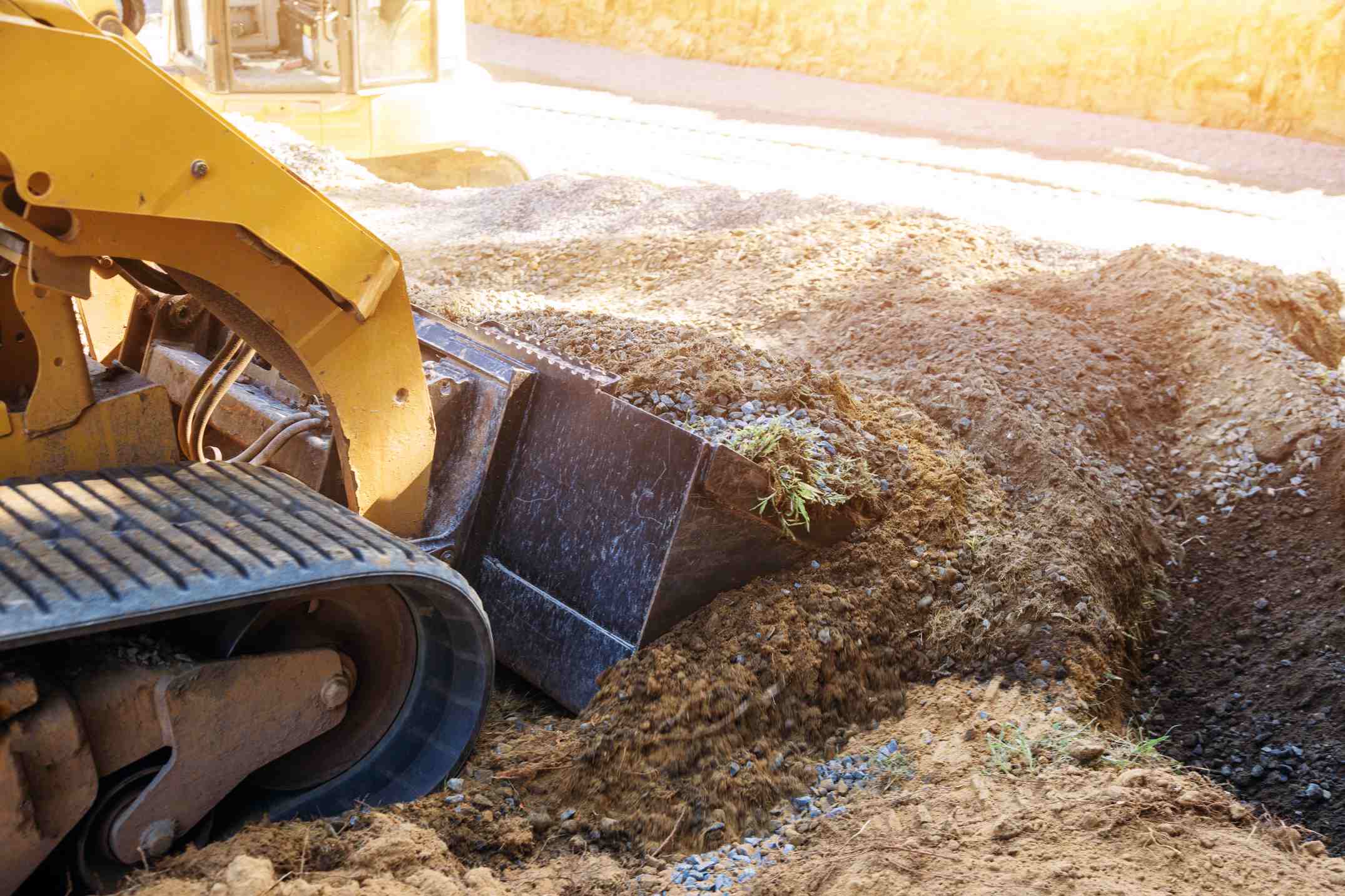 Un engin de chantier effectue des travaux de terrassement dans un jardin particulier