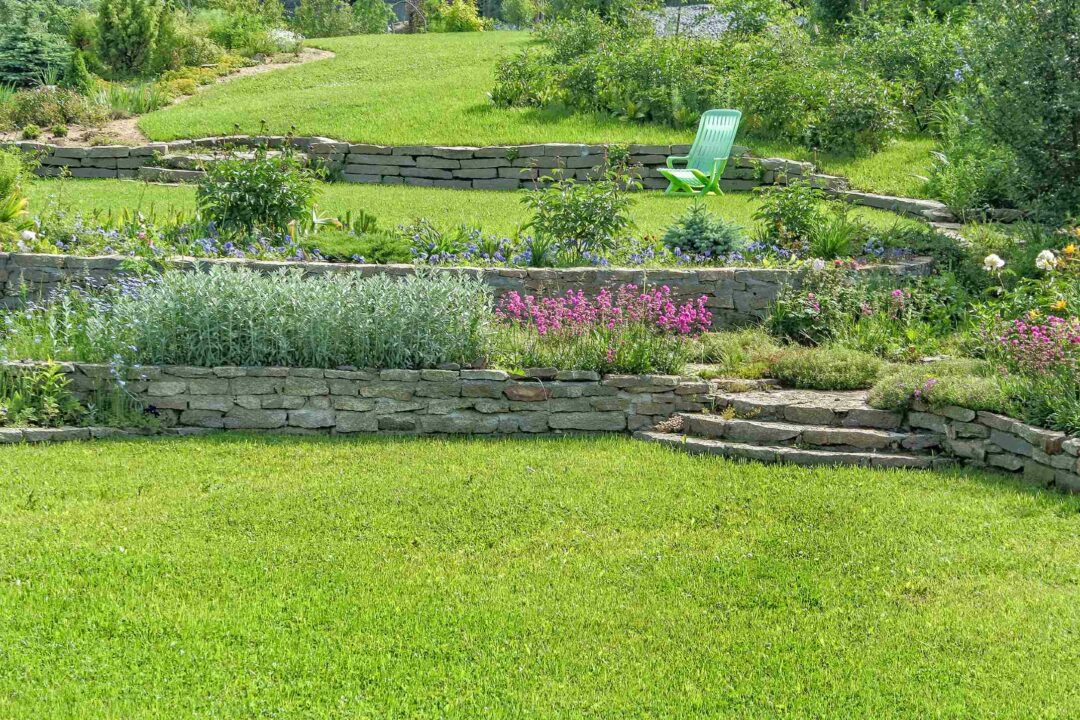 Un beau jardin paysager en terrasse avec pierre naturelle et pelouse