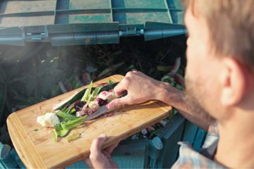 Un homme dépose des déchets organiques et alimentaires dans un composteur