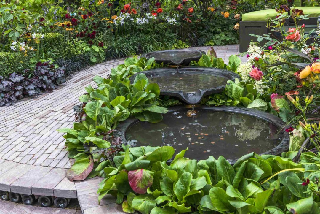 Une fontaine d'inspiration asiatique au sein d'un espace détente dans un jardin paysager