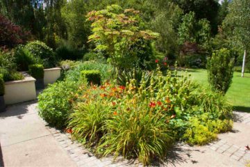 Un massif de plantes et de fleurs à l'entrée d'une propriété