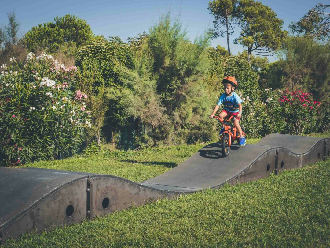 Un enfant fait du vélo sur un parcours skate park