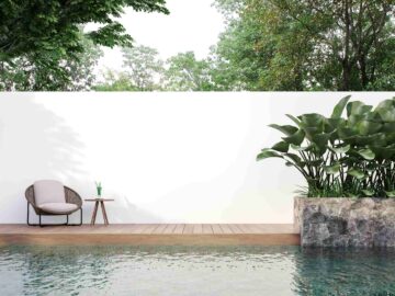 Un mur mitoyen peint en blac derrière une belle piscine