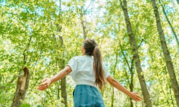 Une femme profite du bon air dans une forêt