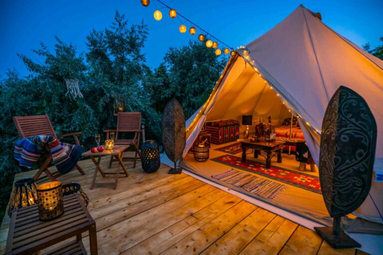 Une terrasse aménagée façon glamping avec tente guirlandes et accessoires