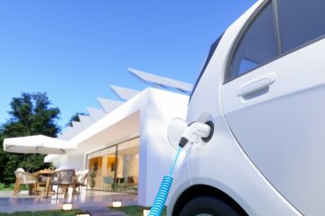 Une voiture électrique en cours de chargement dans le jardin d'un particulier